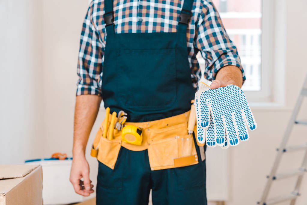 Ausgeschnittener Blick auf Handwerker mit Handschuhen in der Hand - Foto, Bild
