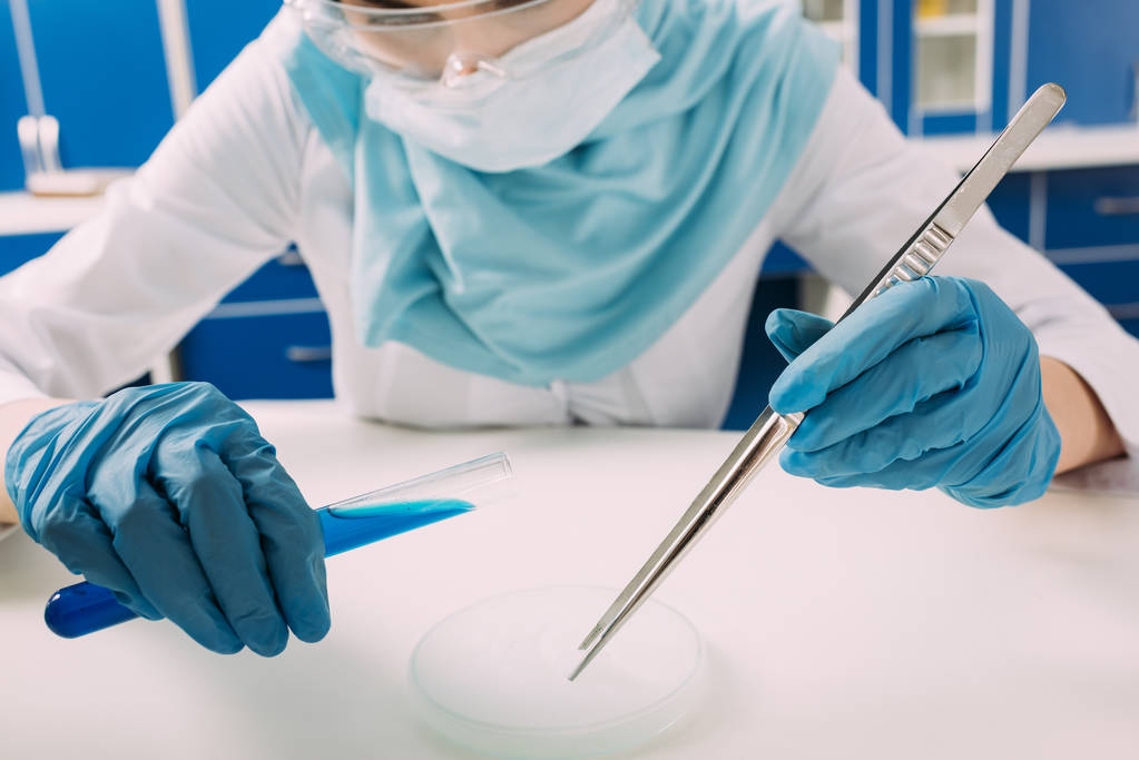 bijgesneden beeld van vrouwelijke islamitische wetenschapper reageerbuis holding met een pincet en experimenteren met droogijs in laboratorium - Foto, afbeelding