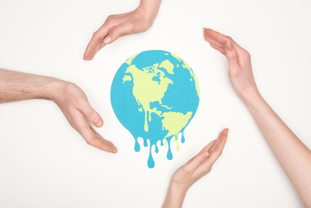 частичный взгляд на мужские и женские руки вокруг бумаги, разрезающей плавильный глобус на белом фоне, концепция глобального потепления
 - Фото, изображение