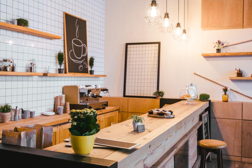 bancone bar marrone in legno con piante e cupcake nella caffetteria
 - Foto, immagini