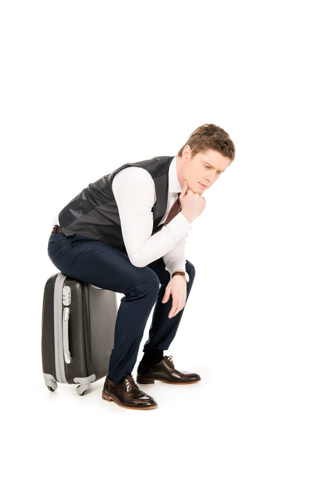 pensativo hombre de negocios sentado en la bolsa de viaje, aislado en blanco
  - Foto, Imagen