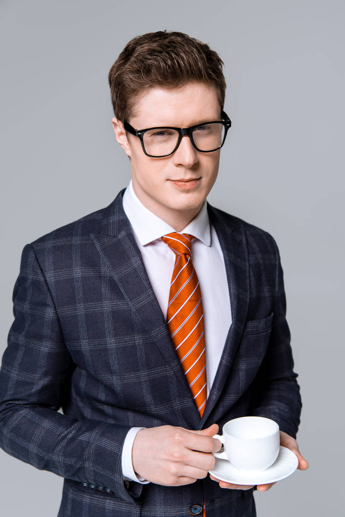 schöner stylischer Geschäftsmann mit einer Tasse Kaffee in grau - Foto, Bild