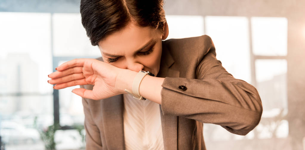 attraente donna spaventata che copre il naso in ufficio con fumo
 - Foto, immagini