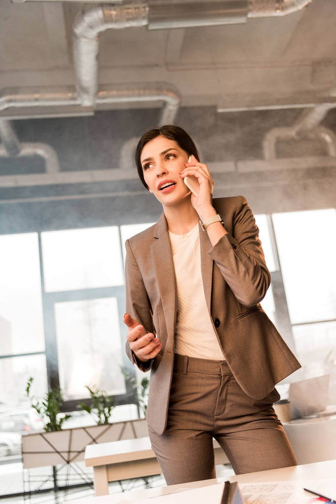 hermosa mujer de negocios hablando en teléfono inteligente en la oficina con humo
 - Foto, Imagen