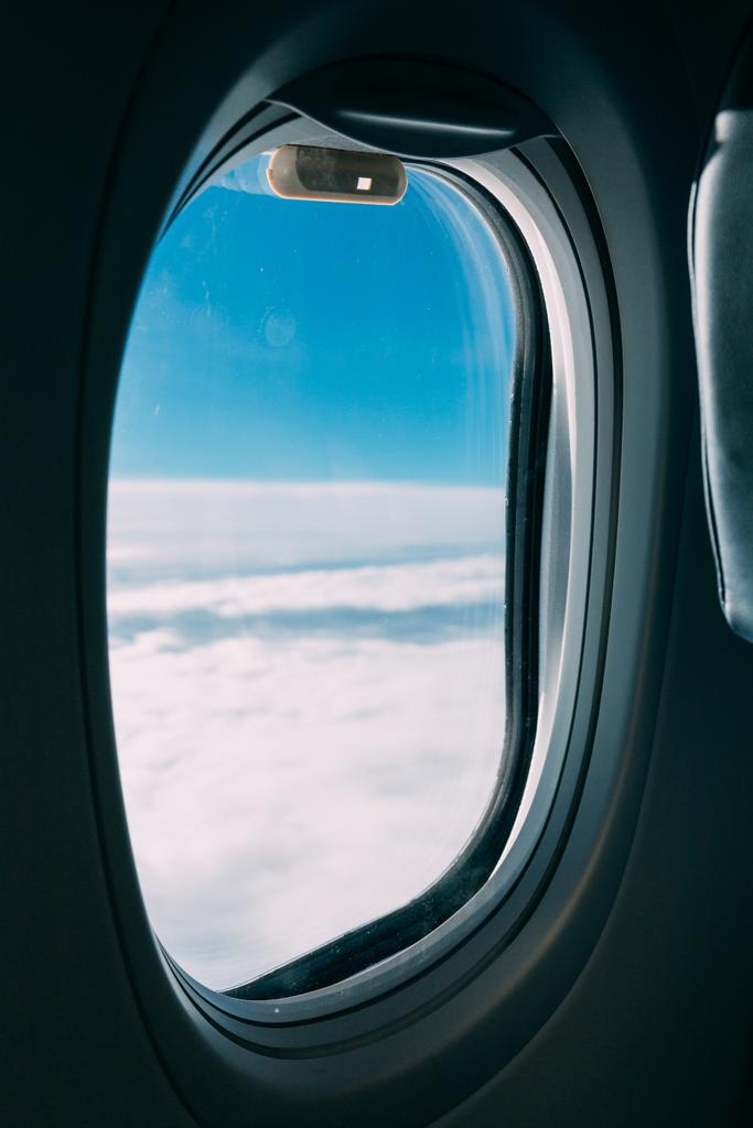 ventana del avión con vista al cielo azul nublado
 - Foto, imagen