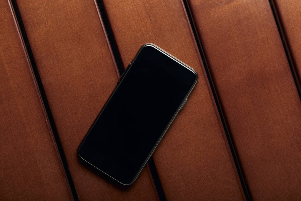 vista superior del teléfono inteligente con pantalla en blanco y espacio de copia en la mesa de madera
 - Foto, Imagen
