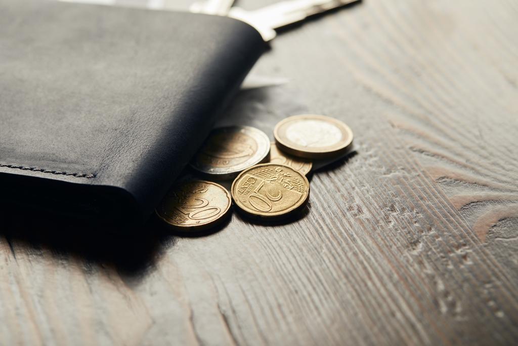 Detailní záběr kožená peněženka a mincí na dřevěný stůl  - Fotografie, Obrázek