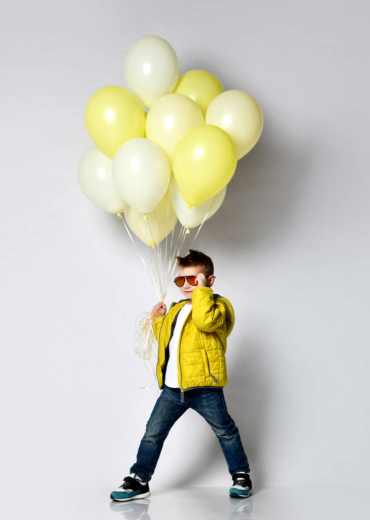 Stylový chlapeček držící vzduchový balón izolovaný na bílém - Fotografie, Obrázek