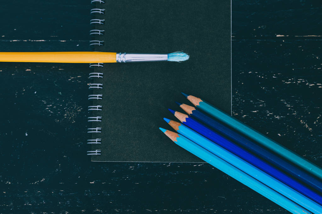 escritorio negro con bloc de notas negro y lápices de color con watercolou
 - Foto, imagen