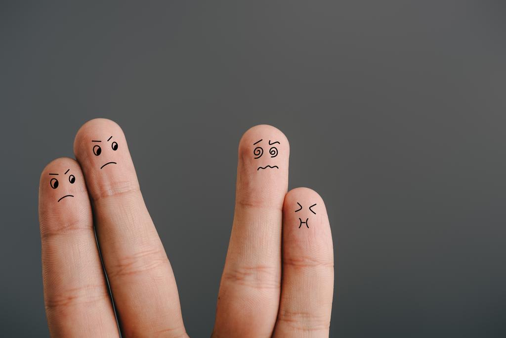 обрізаний вид на сердиту пару, дивлячись на заплутані пальці з нудотою ізольовані на сірому
 - Фото, зображення