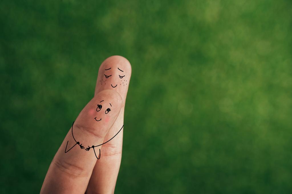 обрезанный вид улыбающейся пары пальцев, обнимающих зеленый
 - Фото, изображение