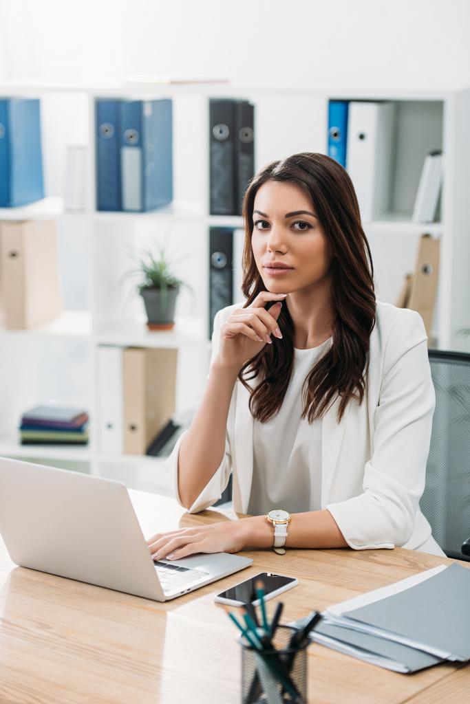 деловая женщина сидит за столом с ноутбуком в офисе
 - Фото, изображение