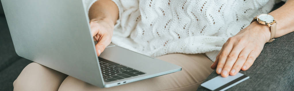 обрезанный вид женщины с помощью ноутбука рядом с кредитной картой дома
 - Фото, изображение