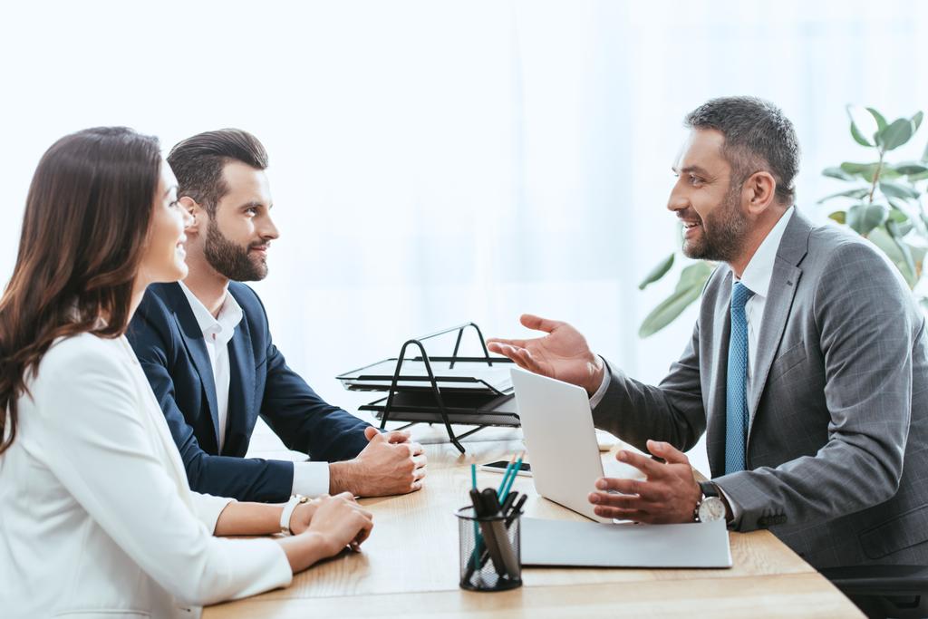 asesor guapo en traje hablando con los inversores en el lugar de trabajo
  - Foto, imagen