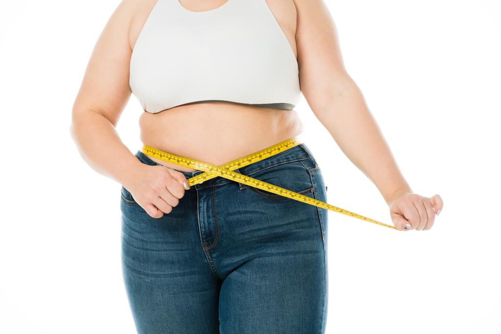 περικοπεί προβολή υπέρβαροι γυναίκας στη μέτρηση μέσης με μεζούρα απομονωθεί σε λευκό τζιν, χάσουν βάρος έννοια - Φωτογραφία, εικόνα