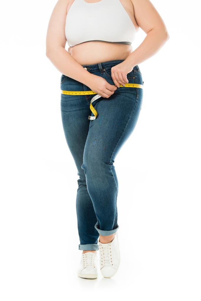 Ausgeschnittene Ansicht einer übergewichtigen Frau, die Hüften isoliert auf Weiß misst - Foto, Bild