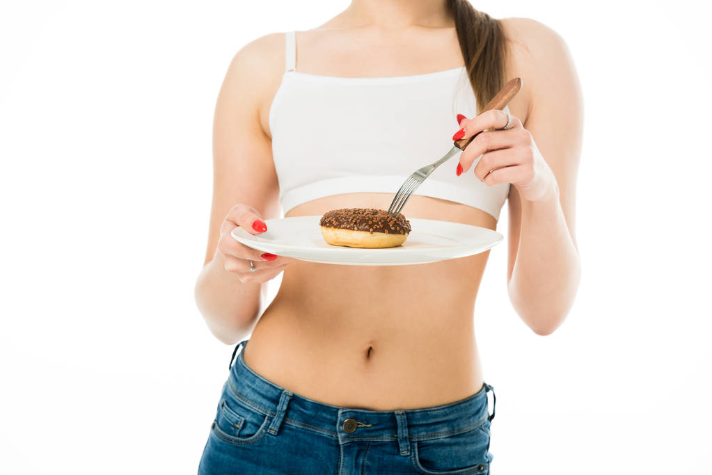 cropped view of slim woman holding sweet delicious doughnut on plate isolated on white - Photo, Image