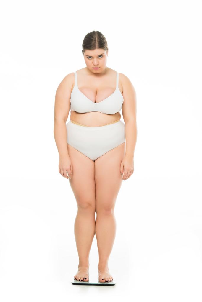 грустная молодая женщина с избыточным весом, стоящая на весах изолированная на белом, похудеть концепция
 - Фото, изображение