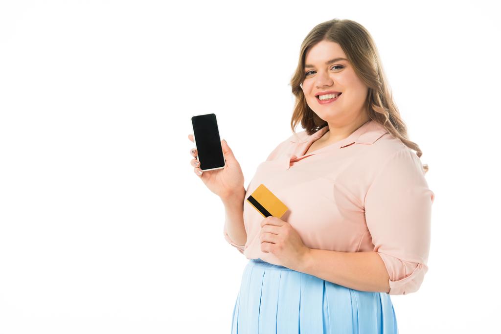 glücklich elegante Plus-Size-Frau hält Smartphone mit leerem Bildschirm und Kreditkarte isoliert auf weiß - Foto, Bild