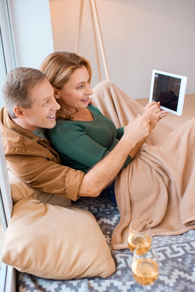 couple gai en utilisant tablette numérique tout en étant assis sur le sol à la nouvelle maison
 - Photo, image
