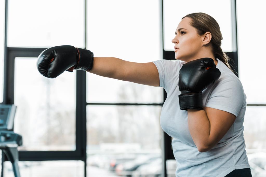 Stark übergewichtige Frau übt Kickboxen im Fitnessstudio - Foto, Bild