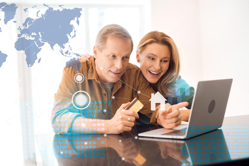 ευτυχισμένο ζευγάρι χρησιμοποιώντας φορητό υπολογιστή μαζί ενώ ο σύζυγός που κατέχουν πιστωτική κάρτα, έξυπνο concept home - Φωτογραφία, εικόνα