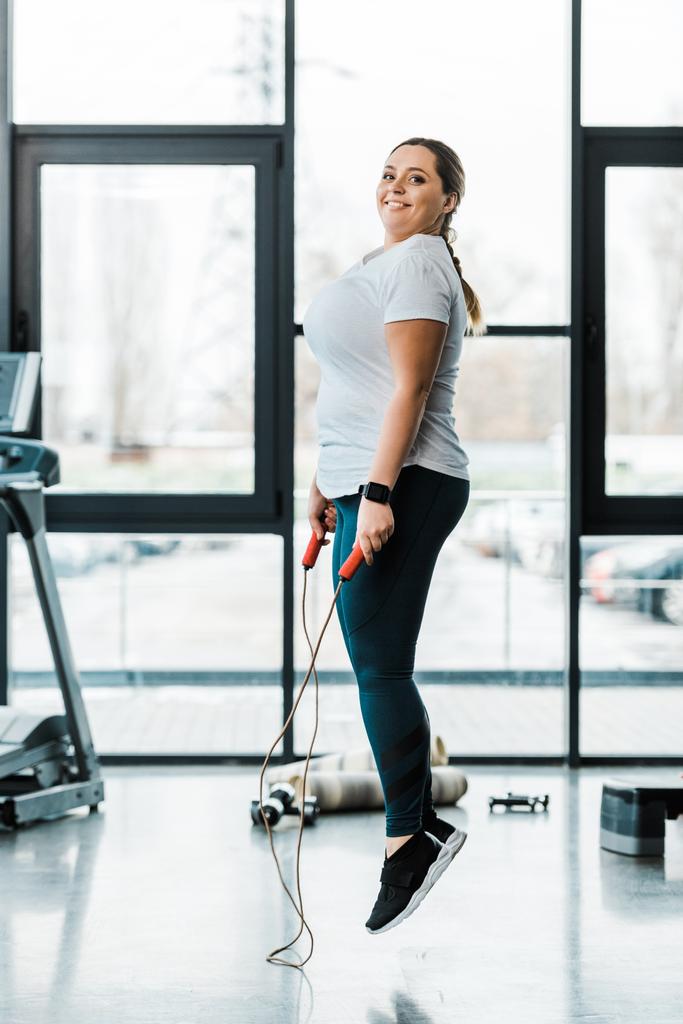 ευτυχισμένη γυναίκα ελκυστική συν μέγεθος, ασκώντας με σχοινάκι σε γυμναστήριο - Φωτογραφία, εικόνα