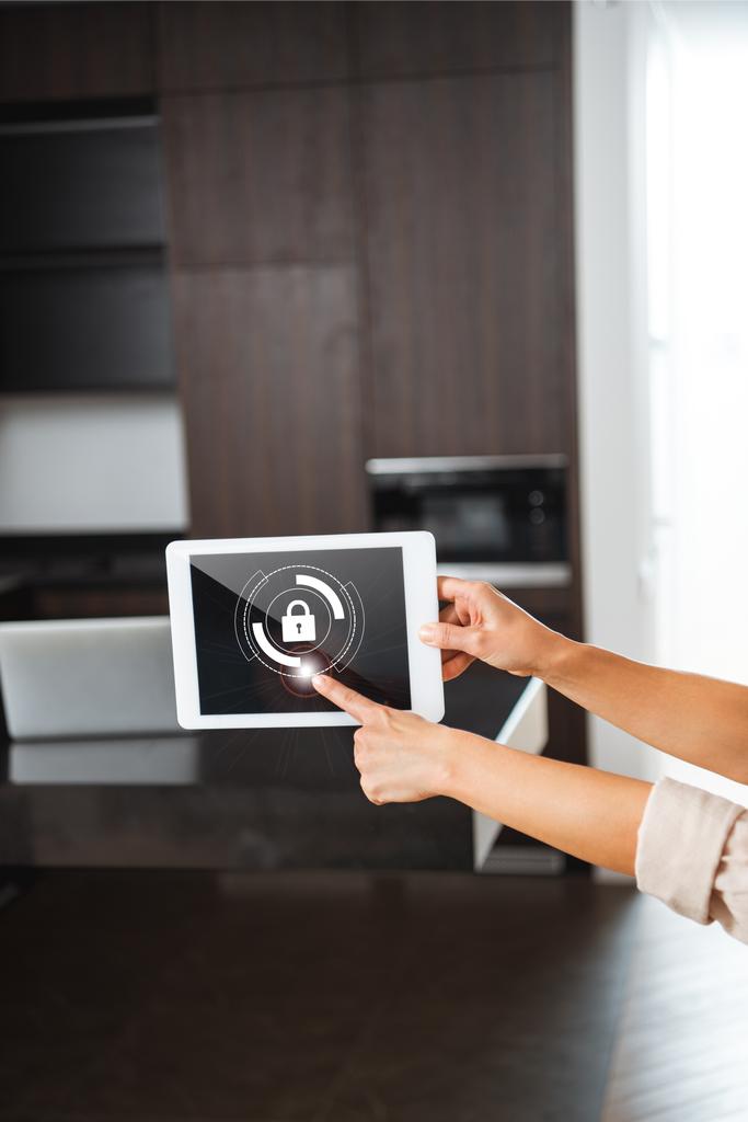 επιλεκτική εστίαση της ψηφιακή ταμπλέτα με εικονογράφηση κλειδαριά ασφαλείας έξυπνο σπίτι στα γυναικεία χέρια - Φωτογραφία, εικόνα