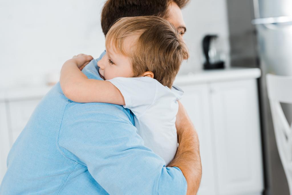 padre abrazando adorable hijo preescolar en casa con espacio de copia
 - Foto, imagen