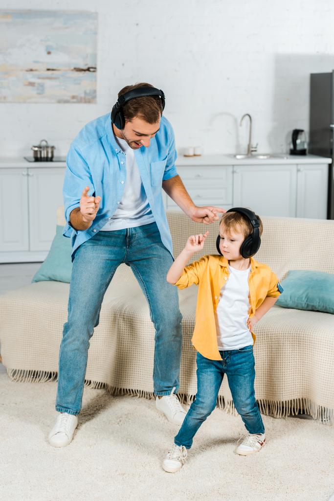 padre con hijo preescolar en auriculares escuchando música y bailando en casa
  - Foto, Imagen