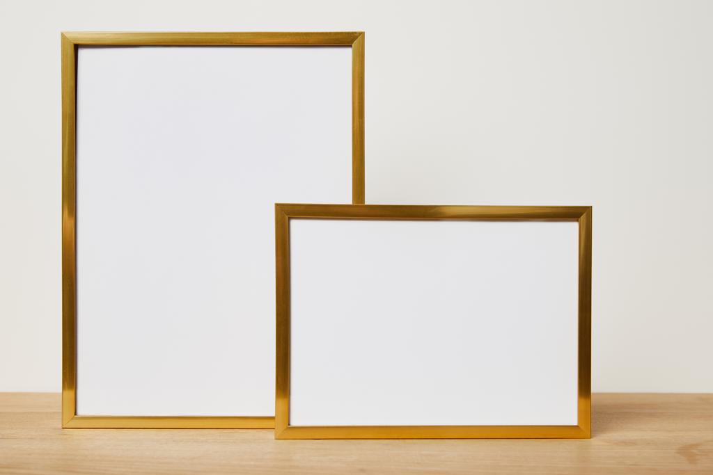 lege frames op houten tafel thuis - Foto, afbeelding