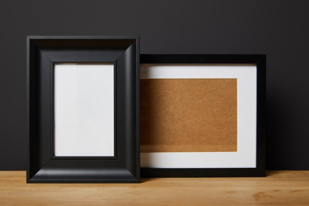 zwarte lege frames op houten tafel thuis - Foto, afbeelding