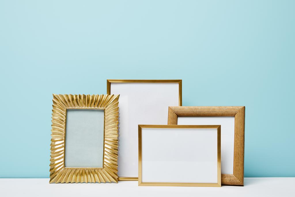blank square decorative frames near blue wall  - Photo, Image