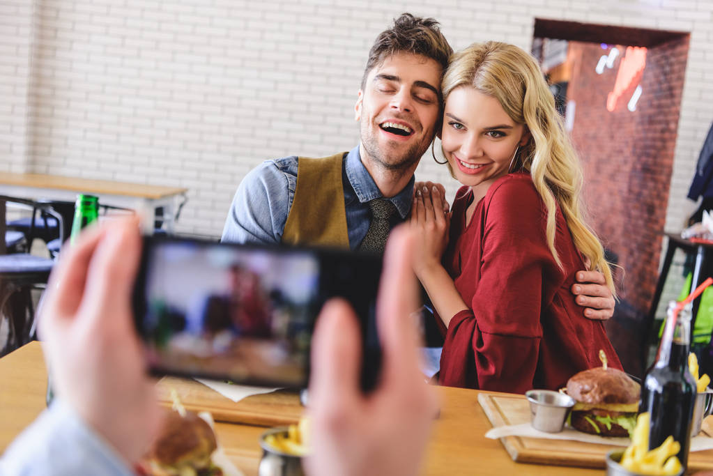 Selektivní fokus krásných a objímání páru, představuje pro fotografii v kavárně  - Fotografie, Obrázek
