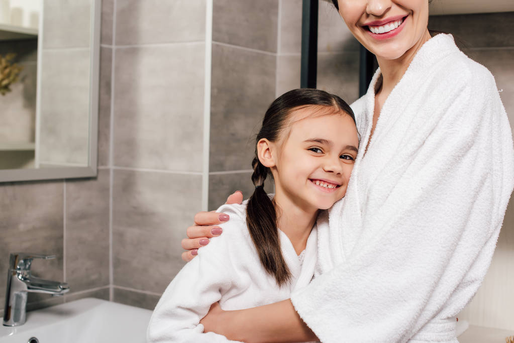 дочка і мати обіймаються і посміхаються у ванній
 - Фото, зображення