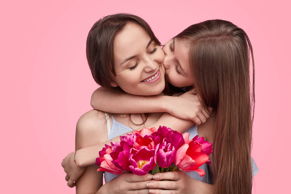 Meisje kussen moeder met lente boeket  - Foto, afbeelding