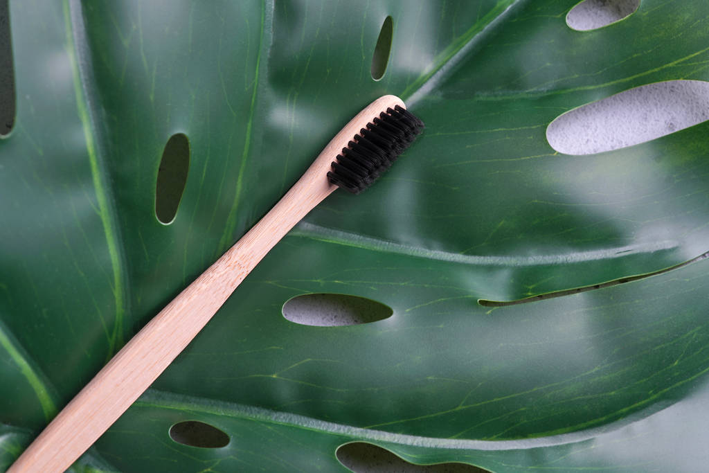 Ecological bamboo toothbrush on monstera leaf - Photo, Image