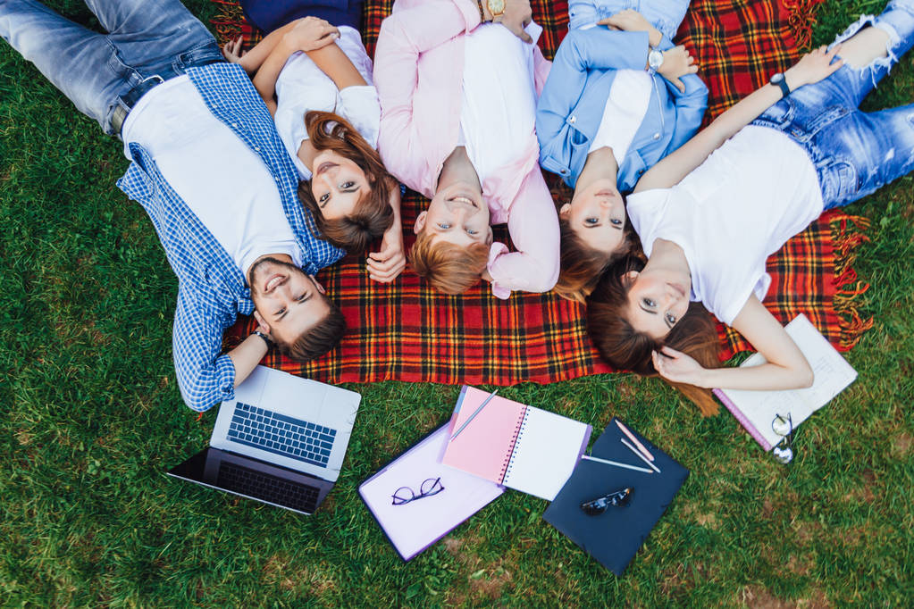 groupe de jeunes étudiants sur l'herbe, se détendre après avoir étudié
 - Photo, image