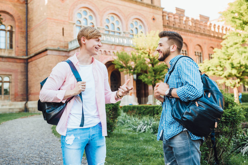 Dos jóvenes estudiantes con mochilas en el campus, se centran en primer plano
 - Foto, Imagen
