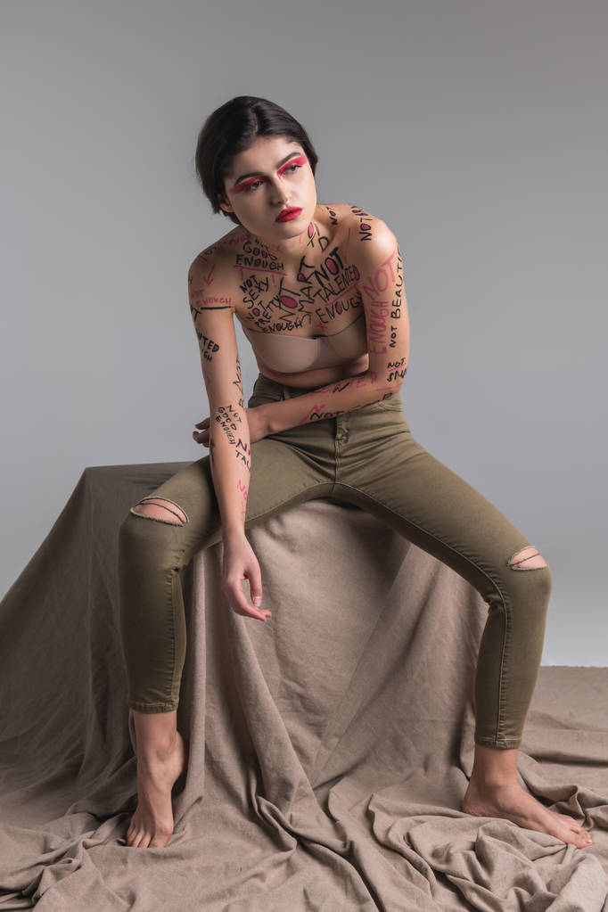 Νέοι μελαχρινή χαριτωμένο λεπτό μοντέλο σε skinny jeans κλίνει προς τα εμπρός - Φωτογραφία, εικόνα
