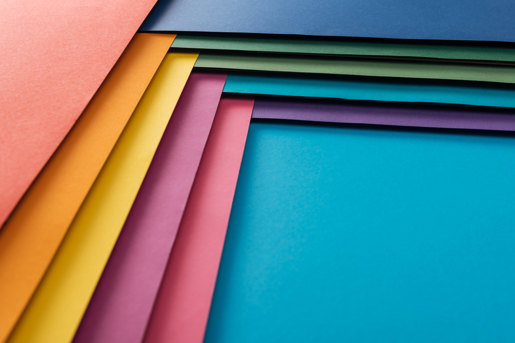  branco azul, borgonha, laranja, verde, amarelo, rosa e roxo folhas de papel sobre fundo azul
 - Foto, Imagem
