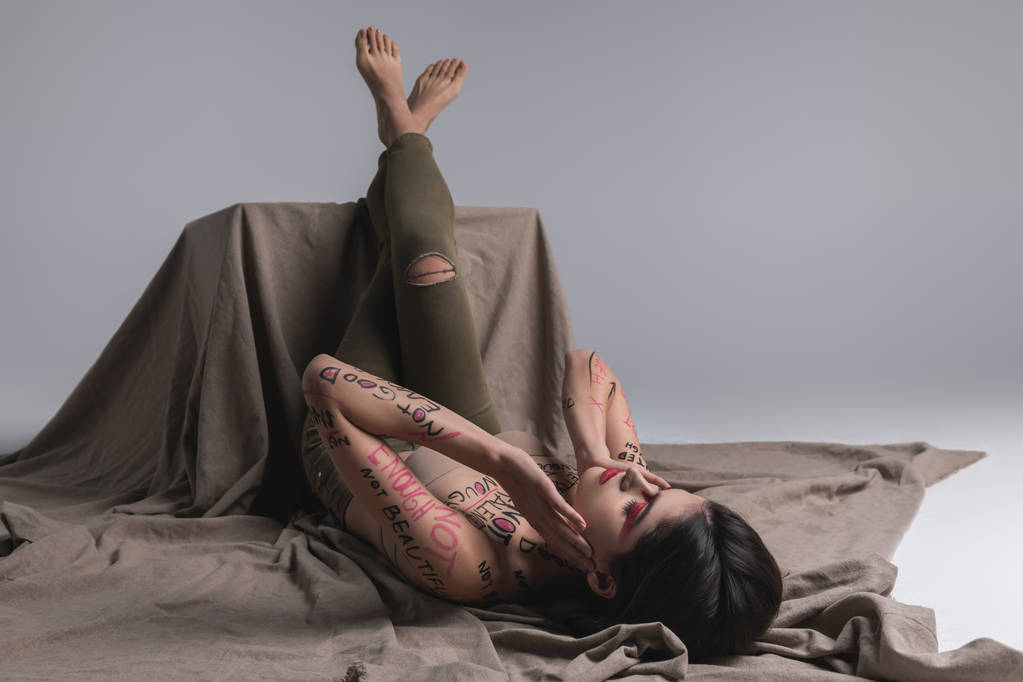 Genç esmer şirin ince model bacakları kaide üzerinde koyarak sıska kot pantolon - Fotoğraf, Görsel