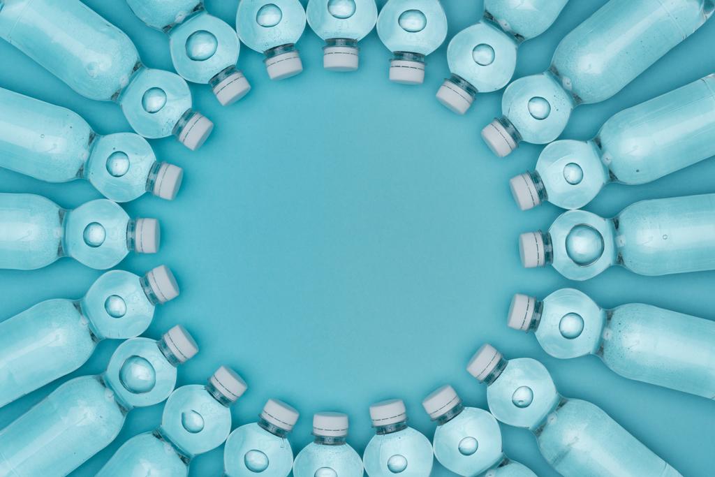 Widok z góry okrągłe ramki wykonane z plastikowych butelek po wodzie na turkusowy z miejsca kopiowania tle - Zdjęcie, obraz