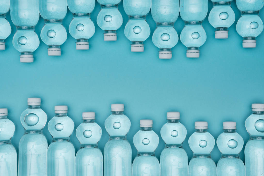 верхний вид организованных пластиковых бутылок воды изолированы на бирюзовой
 - Фото, изображение