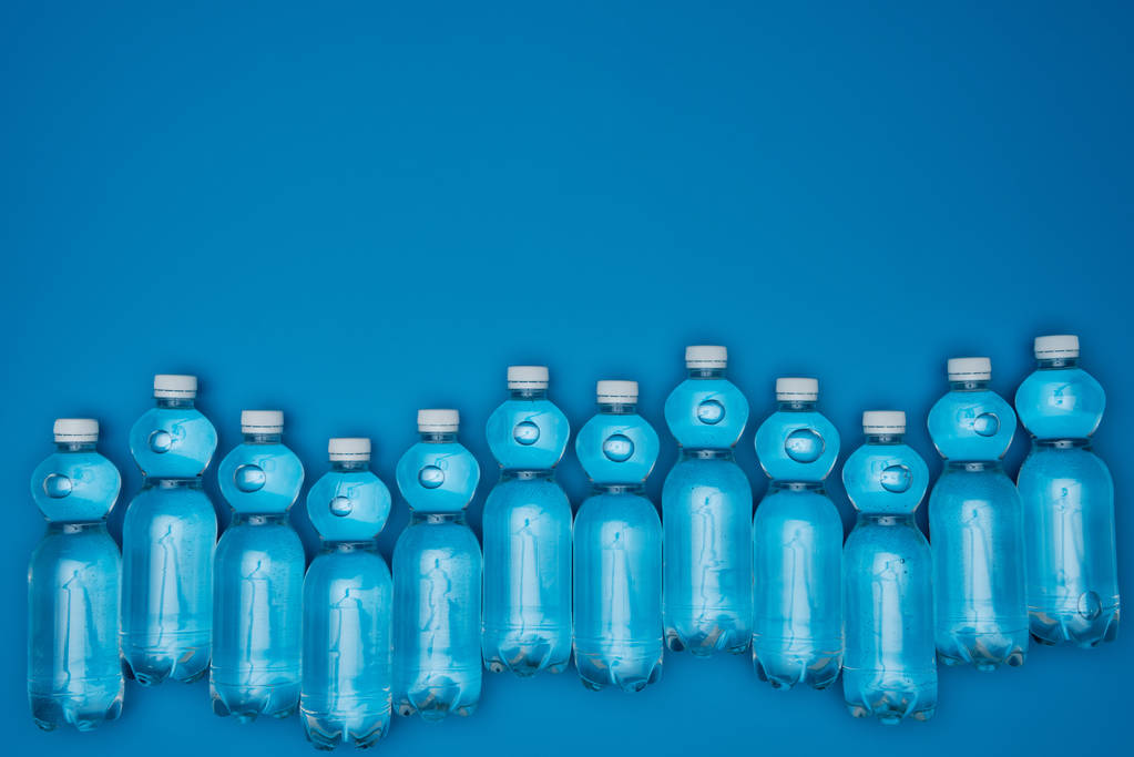 pohled shora uspořádány plastových lahví na vodu izolované na modrý s copy prostor - Fotografie, Obrázek