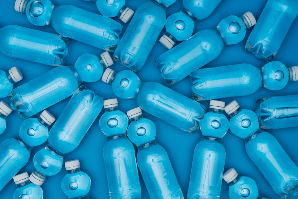 vista superior de garrafas de água de plástico isoladas em azul
 - Foto, Imagem