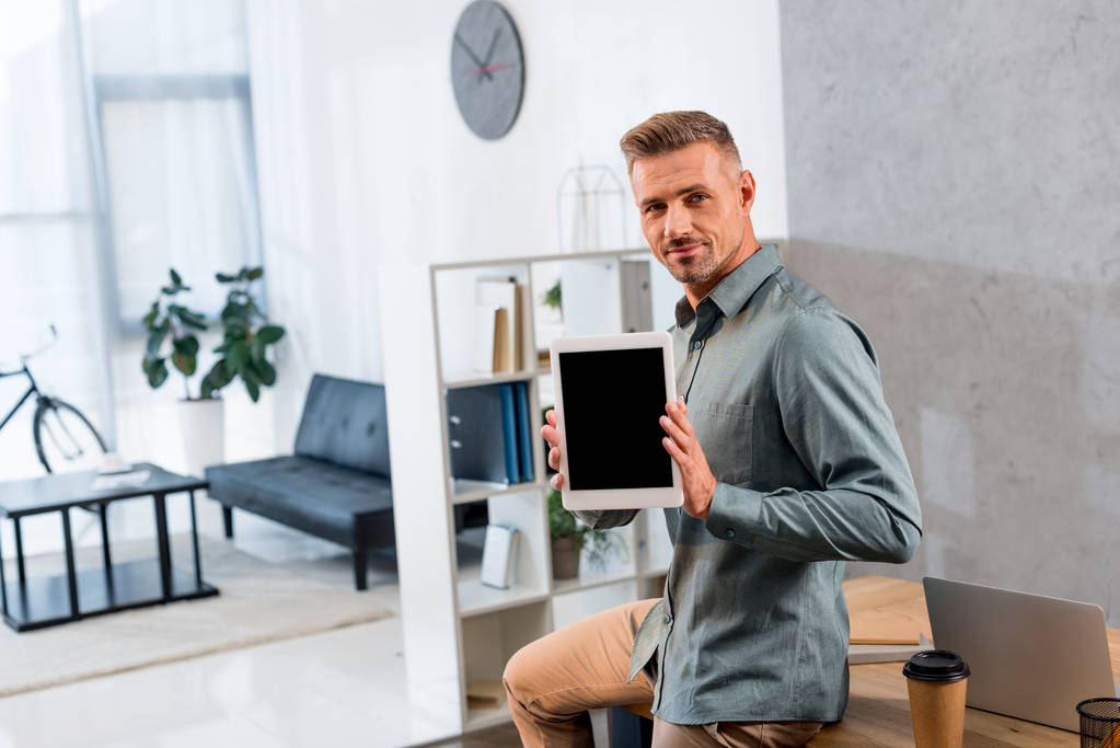 handsome businessman holding digital tablet with blank screen in modern office - Photo, Image
