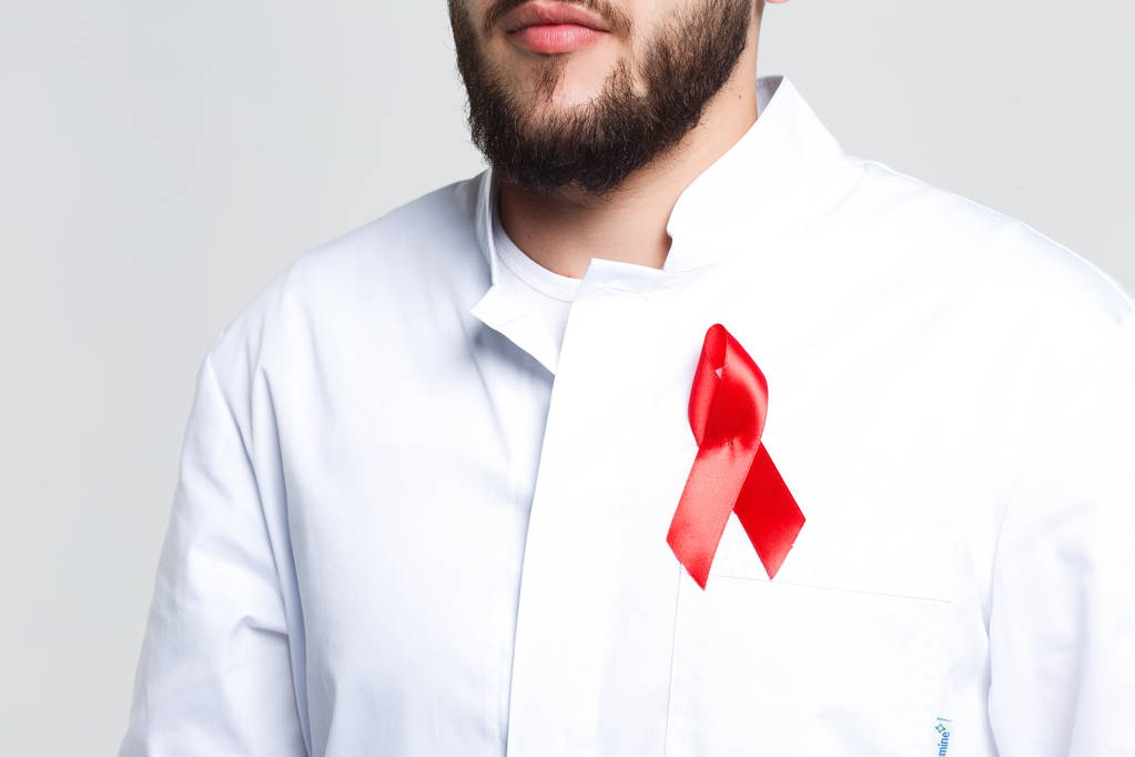 abgeschnittene Ansicht des männlichen Arztes mit rotem Band isoliert auf weißem Hintergrund - Foto, Bild