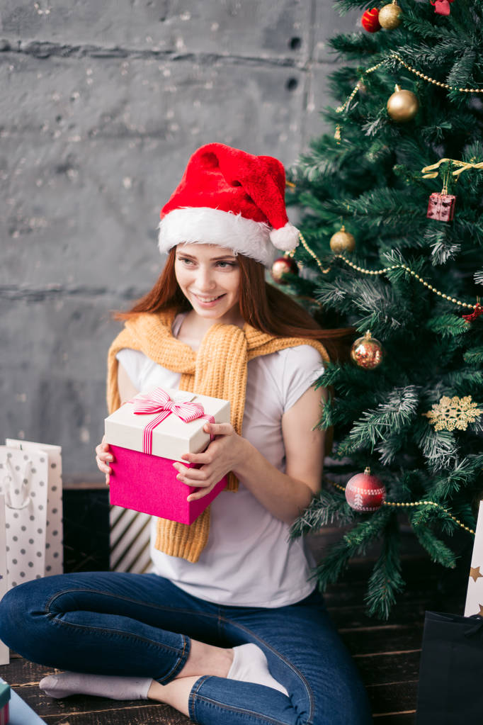 favoriete vakantie, meisje gaat om het geschenk onder de kerstboom - Foto, afbeelding