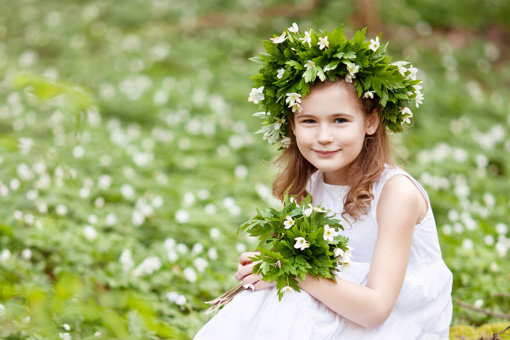 Όμορφο κοριτσάκι σε ένα λευκό φόρεμα βαδίζει στο ξύλο την άνοιξη - Φωτογραφία, εικόνα